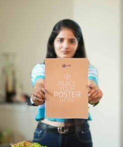 Person holding a blank A4-sized poster with the Pictik logo and 'pictik.in' text, standing indoors with a blurred background.